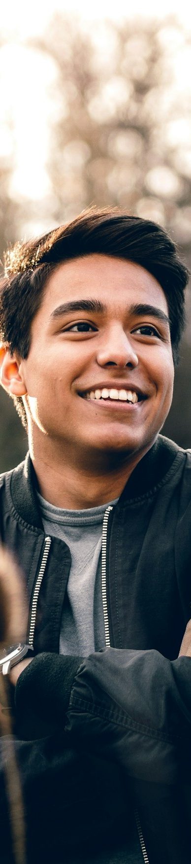 Young man smiling warmly outdoors